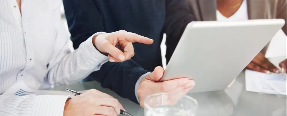 A group of people looking at a tablet.