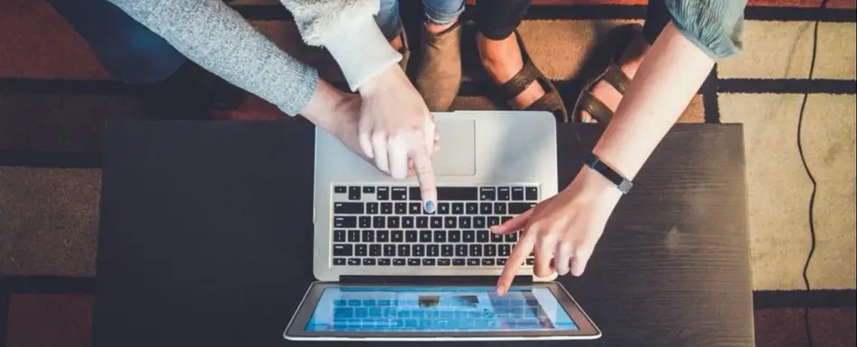 A group of people working and looking at a laptop.