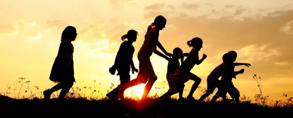 A group of children running past the sun.