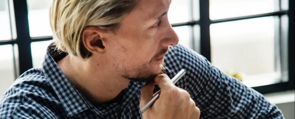 A man looking over his shoulder, deep in thought.