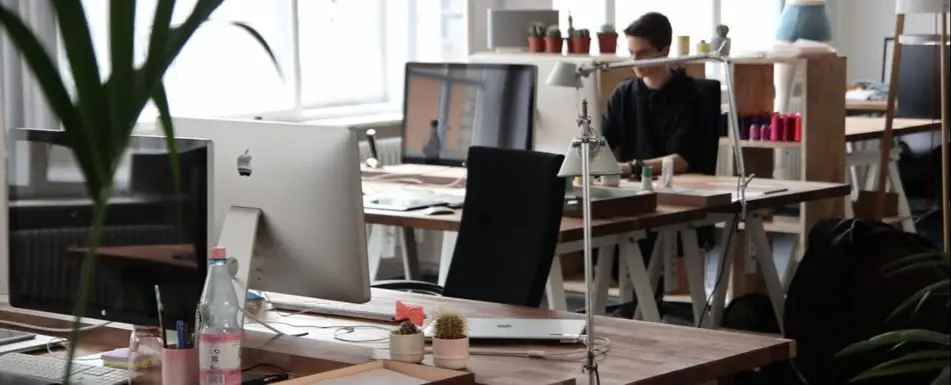 A work office with someone working on a laptop.