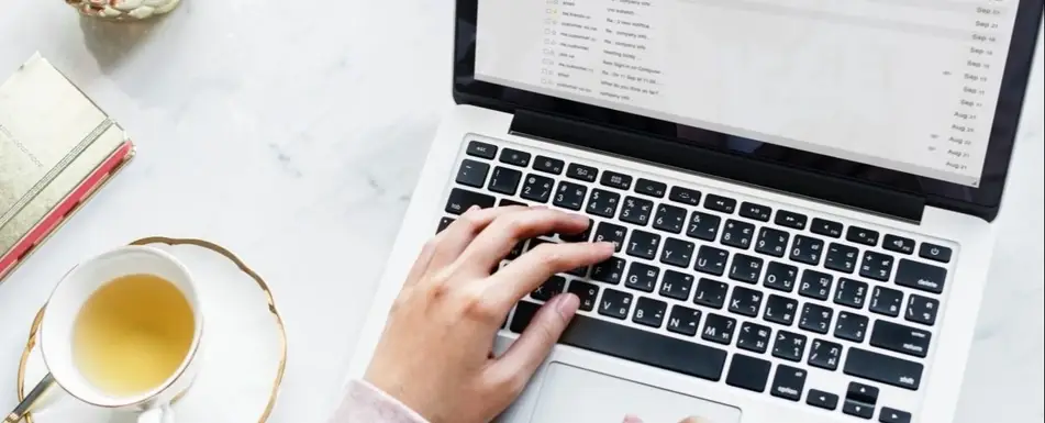 A woman typing at a laptop.