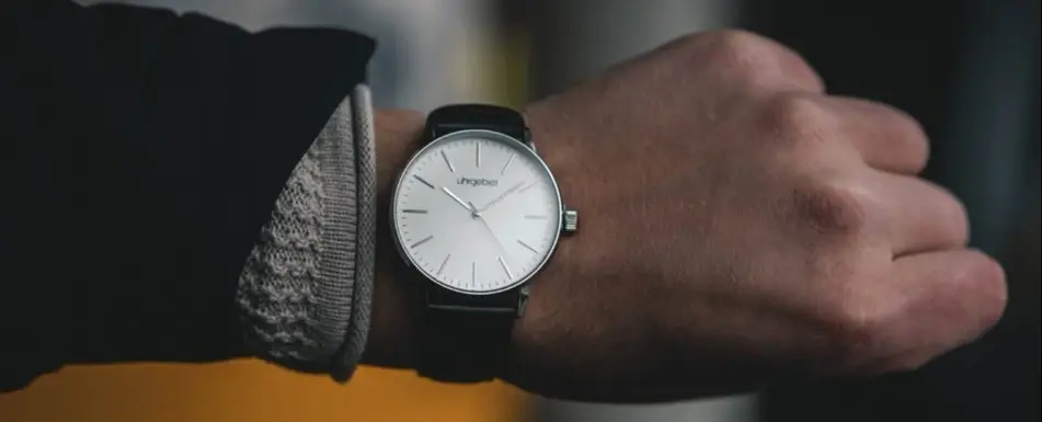 A person showing their wrist watch.