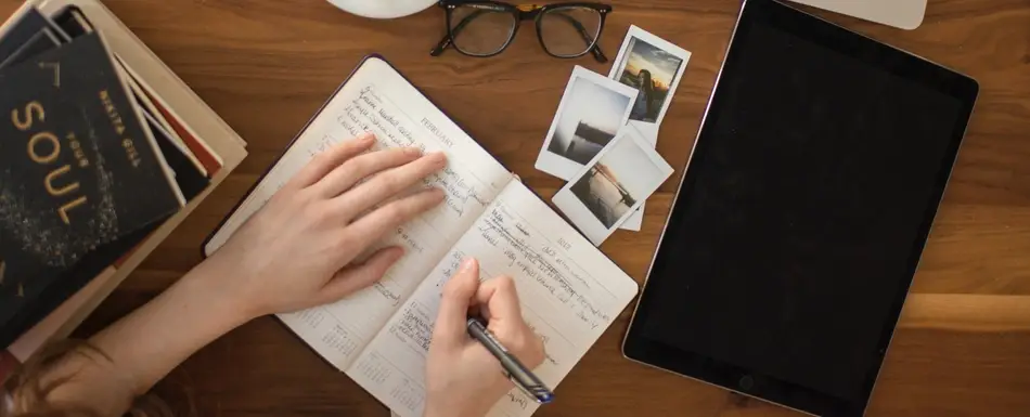 An overhead shot of someone writing in a notebook.