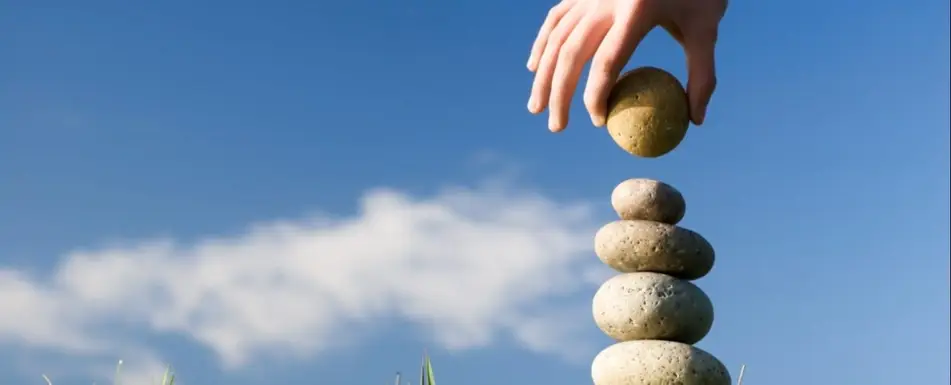 A pile of stones. There's a hand putting a stone at the top.