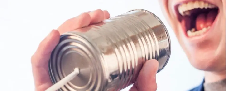 A person talking to a tin can phone.