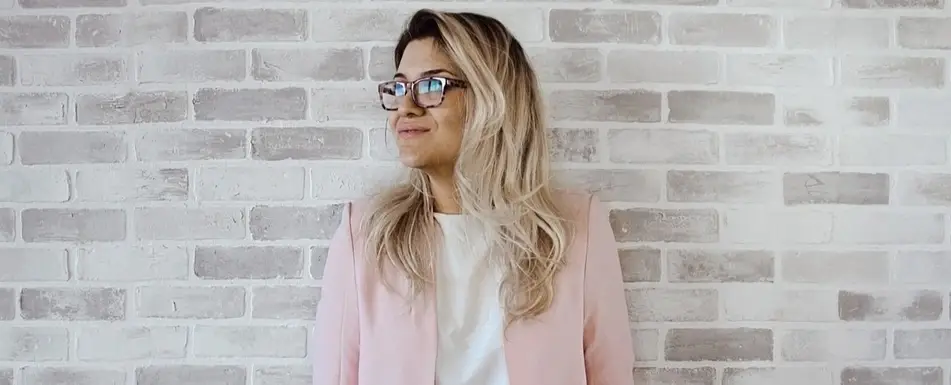 A woman standing in front of a brick wall