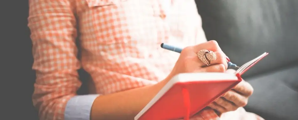 A woman writing in a journal.