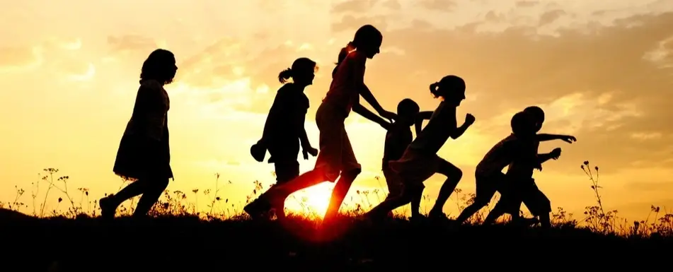 A group of children running past the sun.