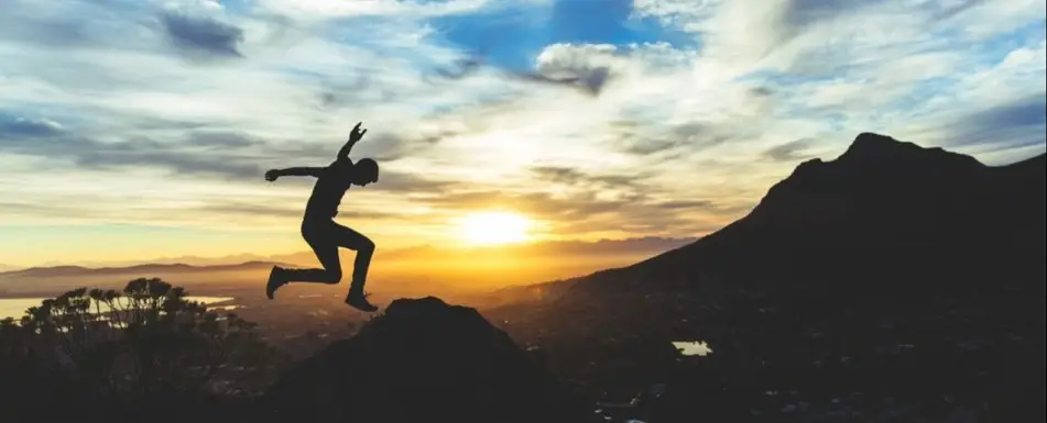 A person jumping on a hill.