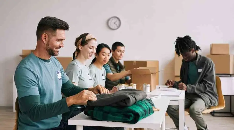 Personas voluntarias recibiendo donaciones de ropa.