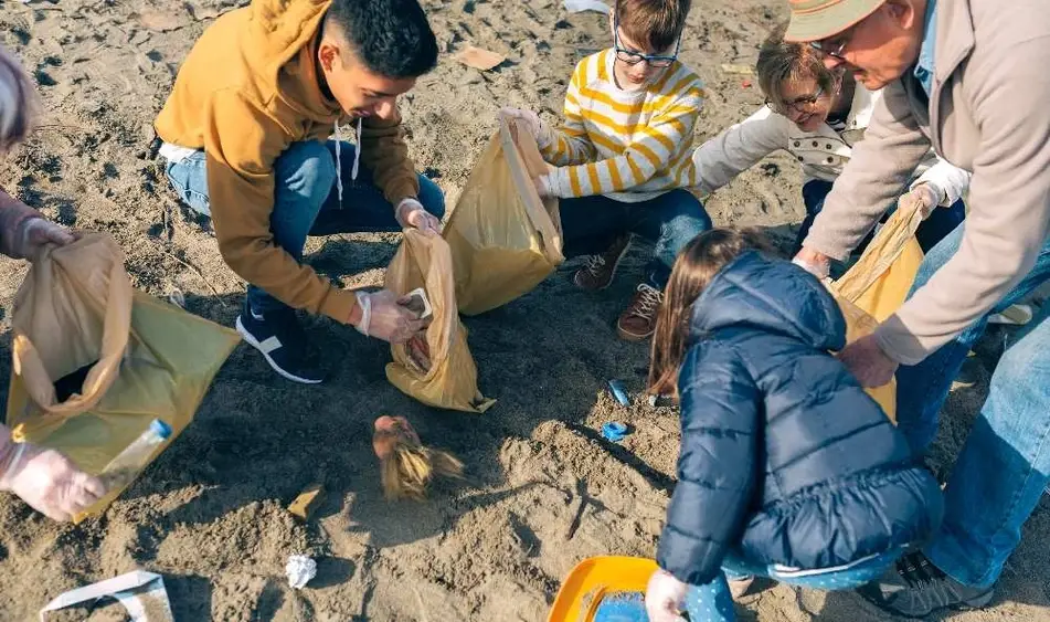 Personas recogiendo basura en la playa