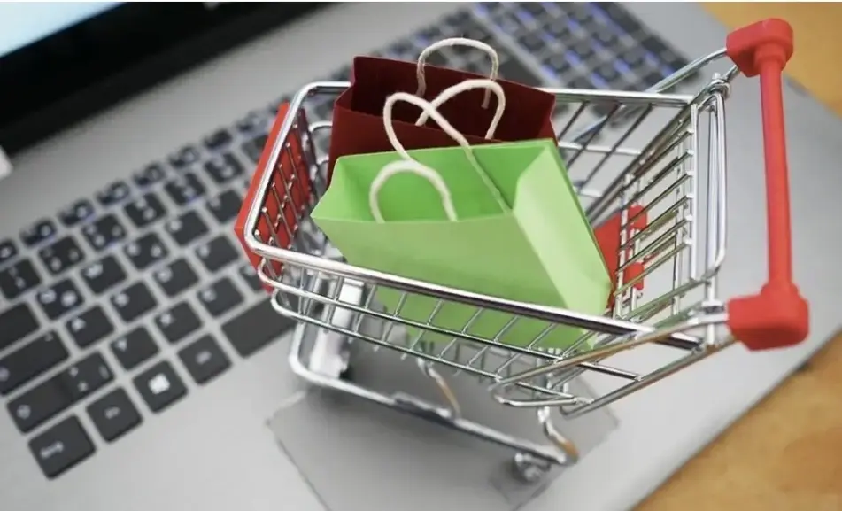 pequeño carrito de la compra sobre el teclado de una computadora