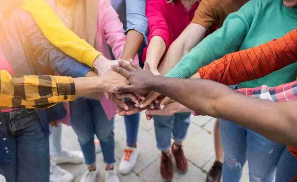 Grupo de mujeres adolescentes juntan sus manos