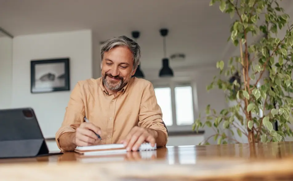 Man writes in professional journal at home.