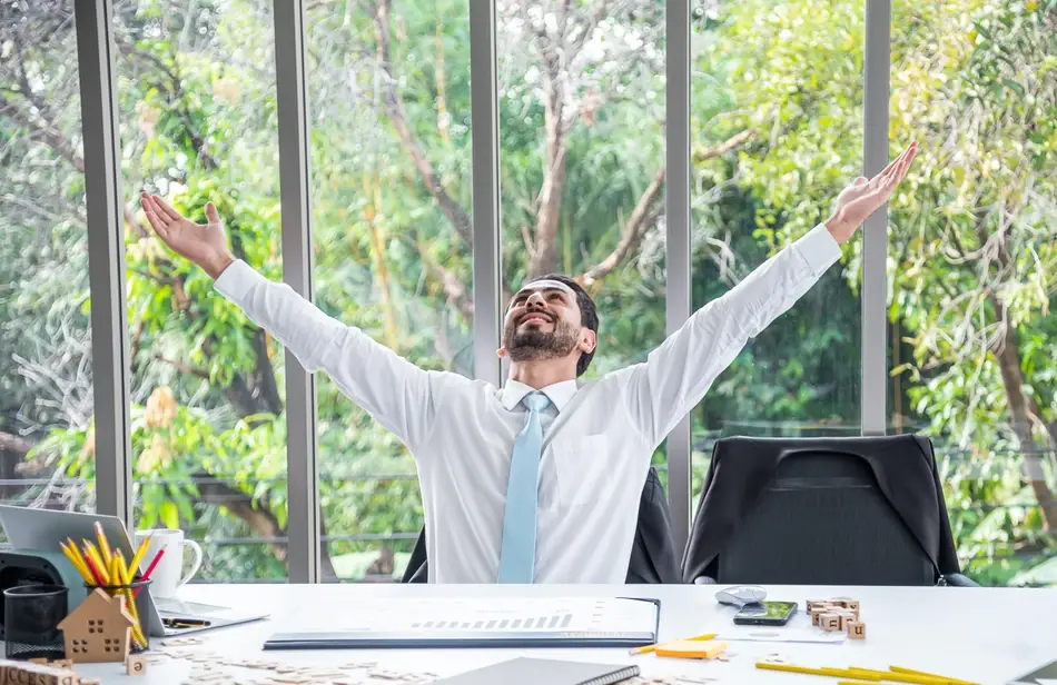 A businessman celebrates a successful performance review at work.