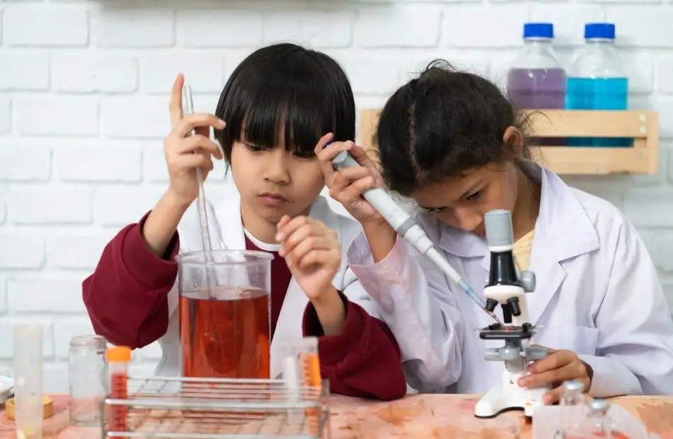 Dos niñas trabajando en un laboratorio de ciencia.