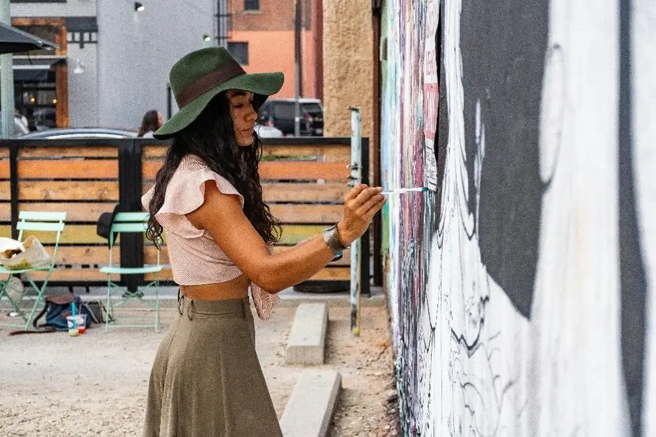 Mujer pintando un mural