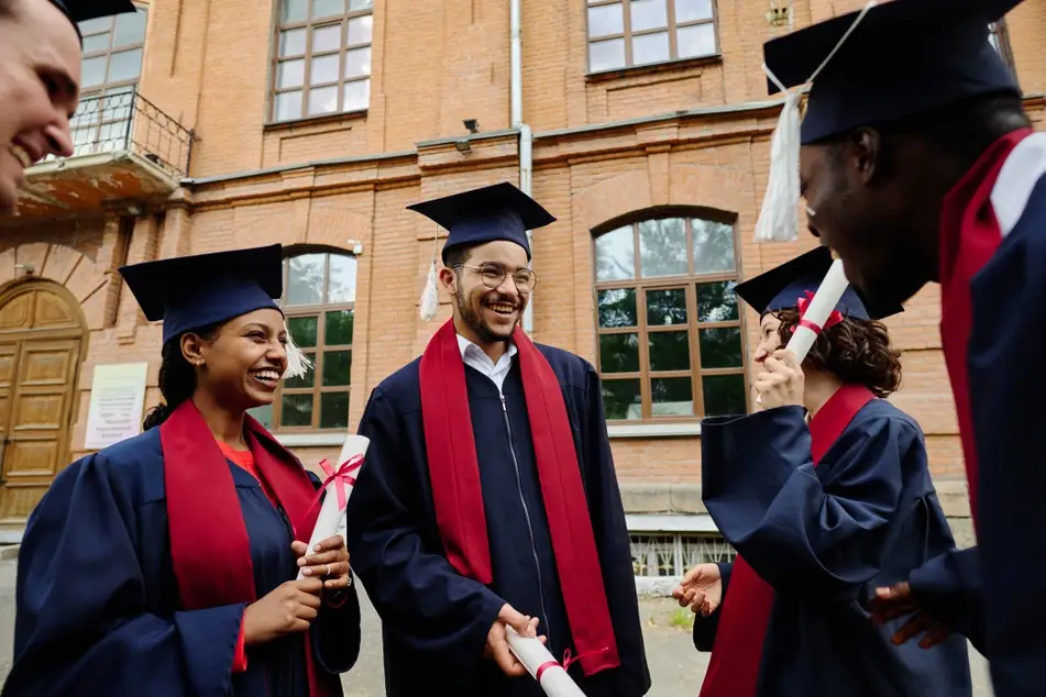 Happy graduate students standing around laughing