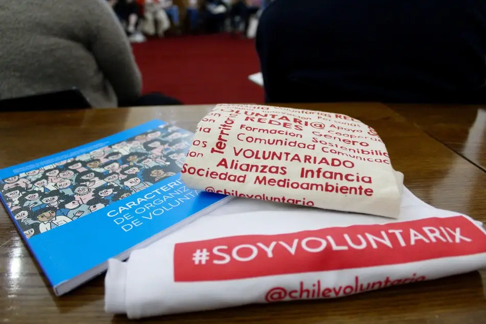 Libro y camiseta con logo de la Red Nacional de Voluntariado en Chile