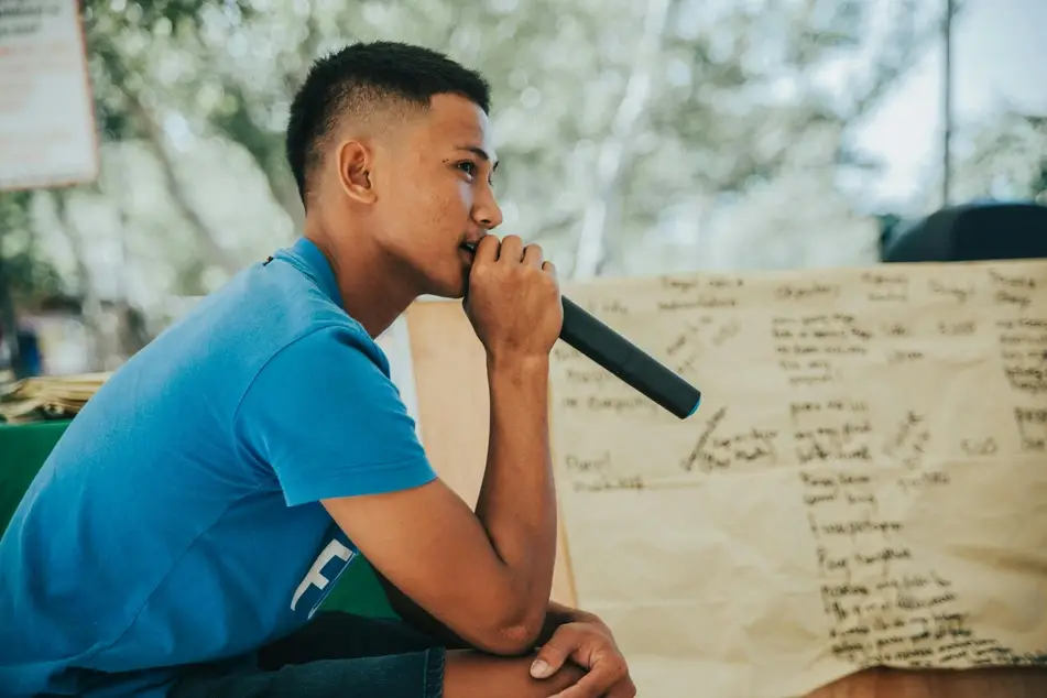 young person speaking into a microphone