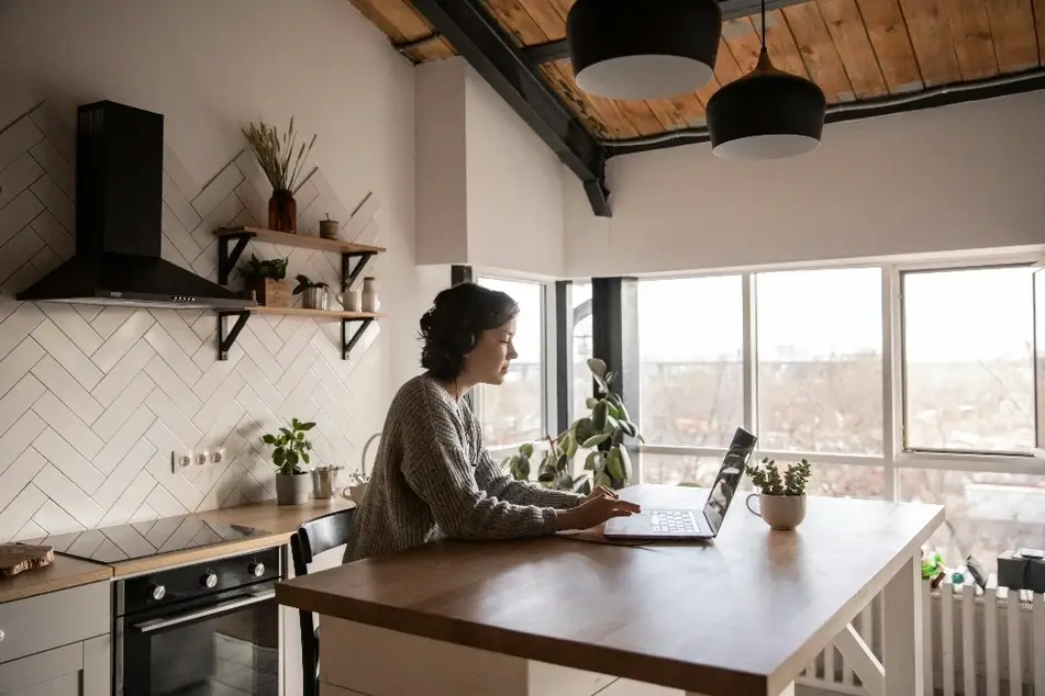 Mujer usando una laptop en una cocina