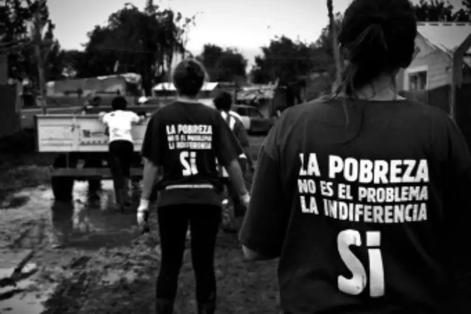 Foto en blanco y negro de voluntarios con camiseta que dice La pobreza no es el problema.  La Indiferencia si.