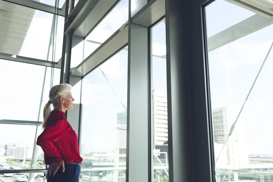 senior businesswoman looking through office window