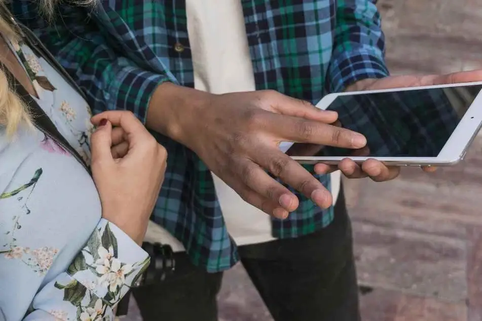 Toma cerrada de dos personas viendo una tablet.