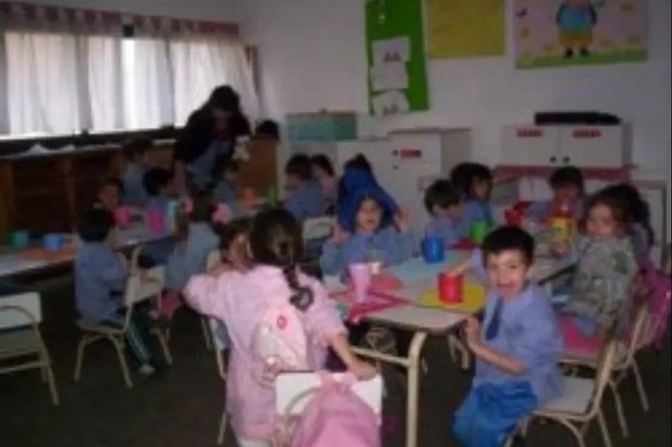 Una sala escolar con varios niños haciendo actividades