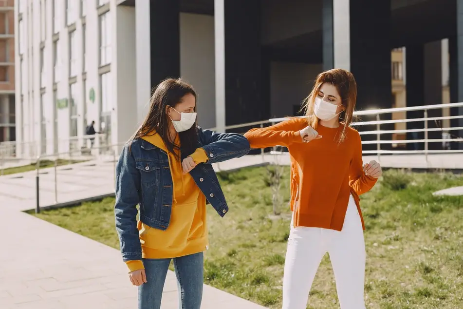 two women elbow bumping