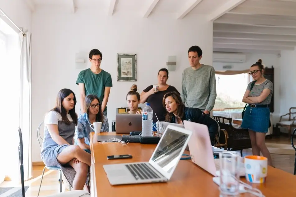 Grupo de personas mirando una laptop en una oficina