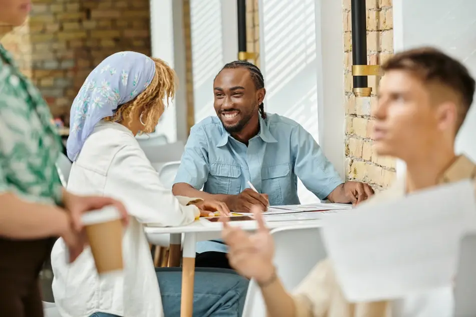 Two co-workers chat happily while sitting outside at office