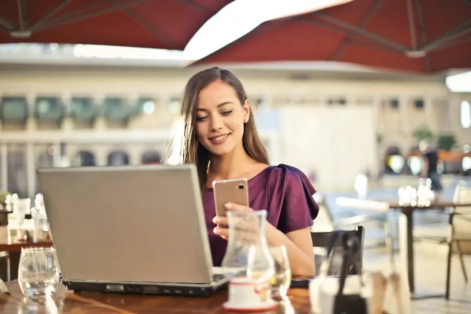 Mujer sentada en un café mirando su celular