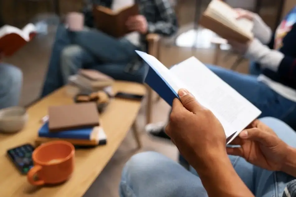 Manos y libros, personas reunidas leyendo.