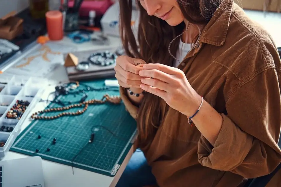 Mujer elaborando una pieza de bisutería en su taller.