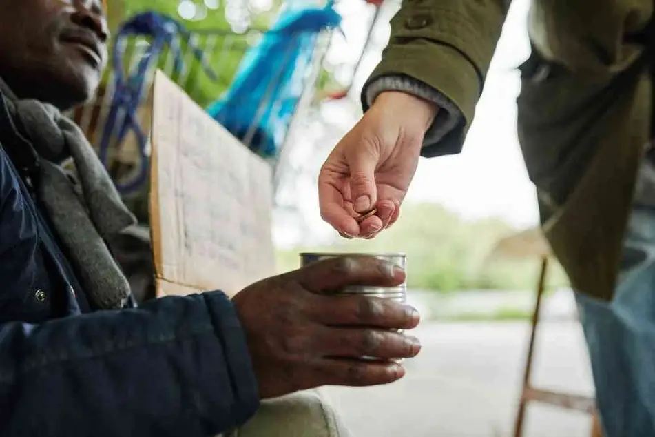 Hombre habitante de calle y persona dándole dinero