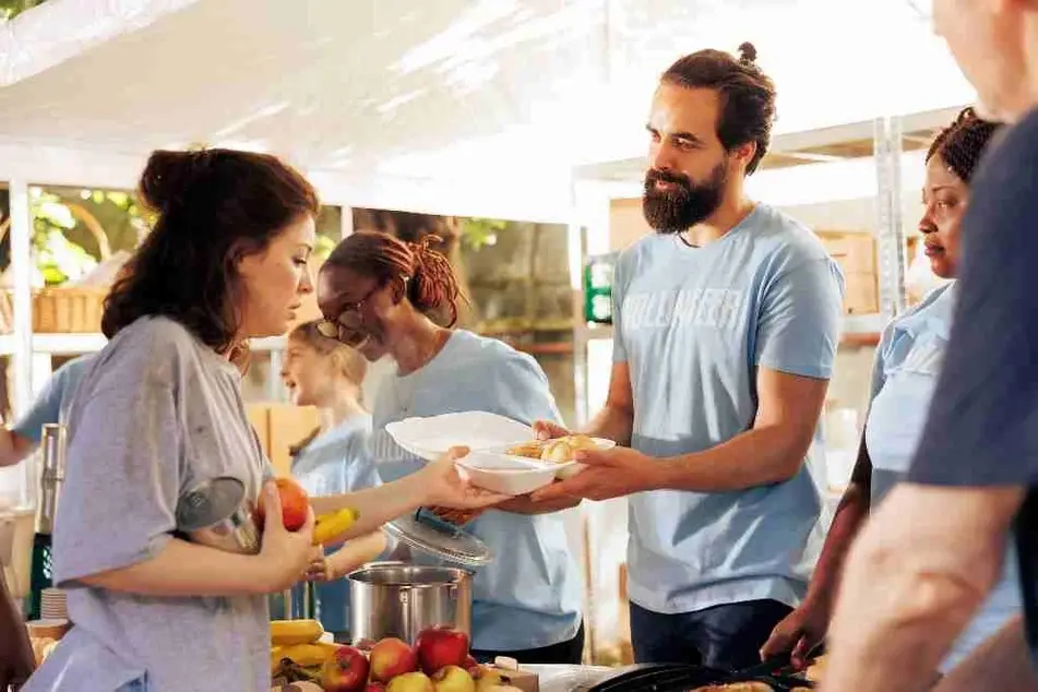 Personas voluntarias entregan comida a quien lo necesita.