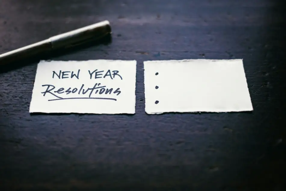 Pedacinho de papel com o escrito "New Year Resolutions" (resolução de ano novo) e três pontinhos