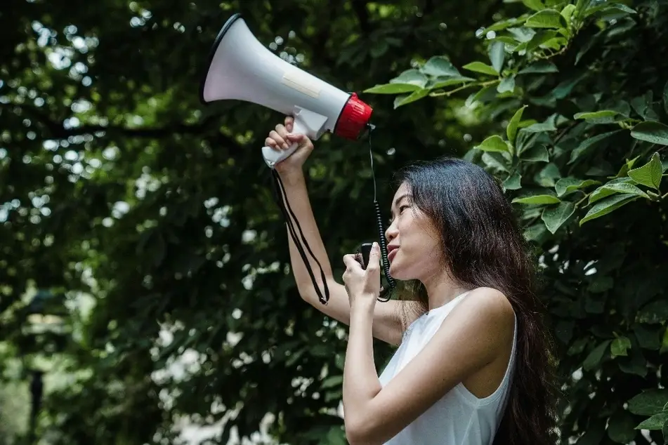 Mujer joven sosteniendo un megáfono