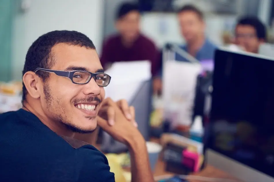 Chico sonriente frente a su computador