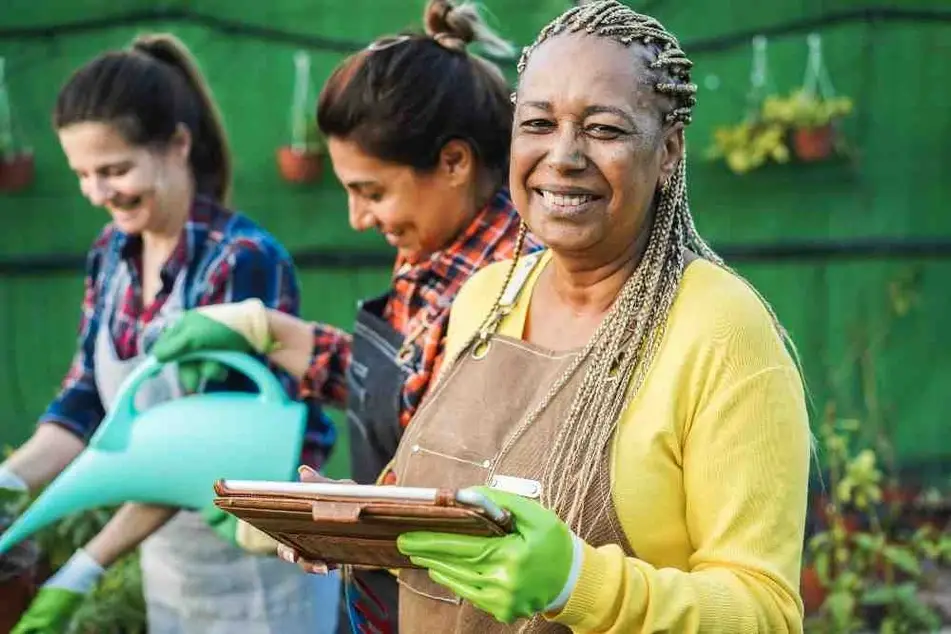 Mujeres que trabajan en el jardín de invernadero.