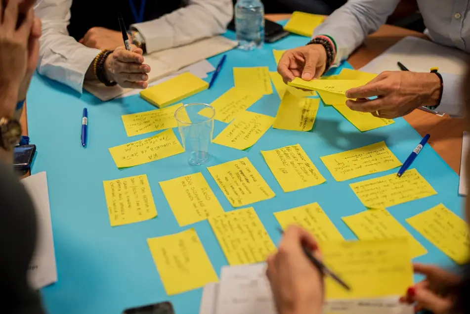 Un equipo de trabajo en una sesión creativa escribiendo ideas en post its