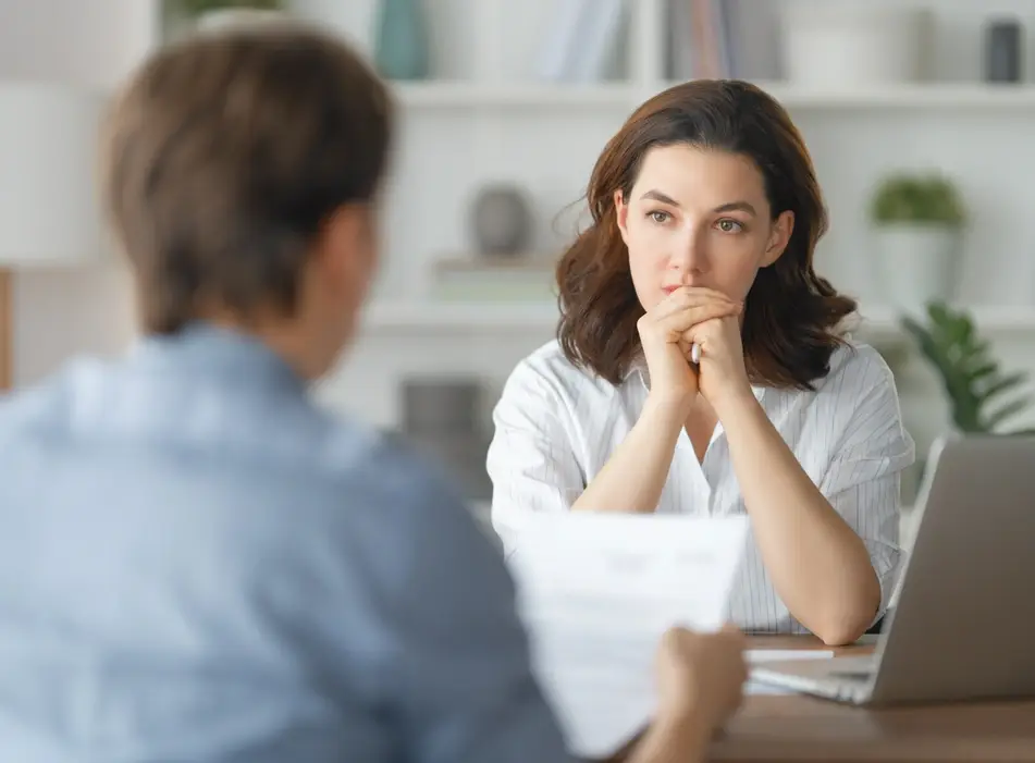 White woman facing interviewer and answering a problem solving interview question.