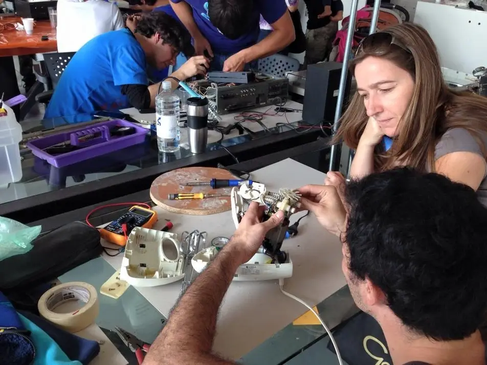 Personas arreglando objetos en un taller comunitario de reparación